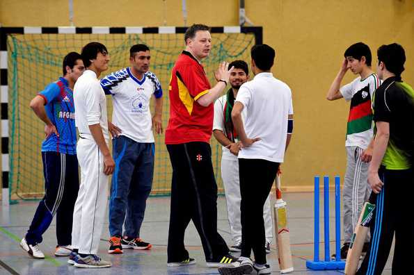 Brian Mantle (C), President of the Deutscher Cricket Bund (DCB) oversees a training session with refugees from Afghanistan in Essen, western Germany.