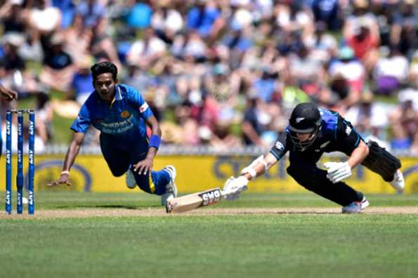 Chamara Kapugedera (L) of Sri Lanka runs out Mitchell Santner during the 3rd One Day International match against New Zealand at Saxton Oval in Nelson