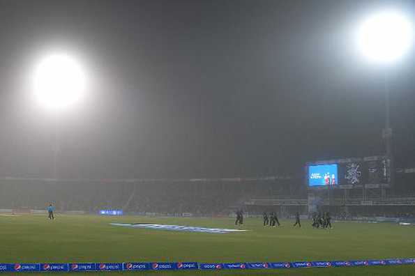 Pakistani cricketers leave the ground amid a sandstorm.