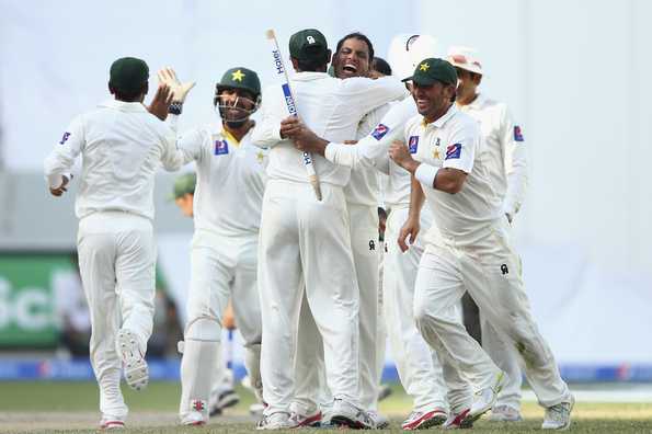 Zulfiqar Babar celebrates with his team-mates after taking the final wicket.