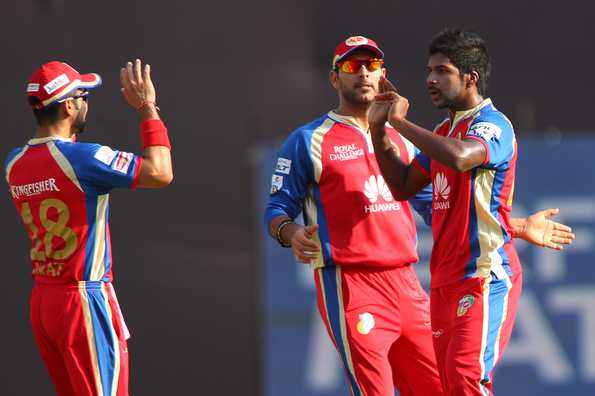 Varun Aaron celebrates the wicket of Dwayne Smith with Yuvraj Singh and Virat Kohli.