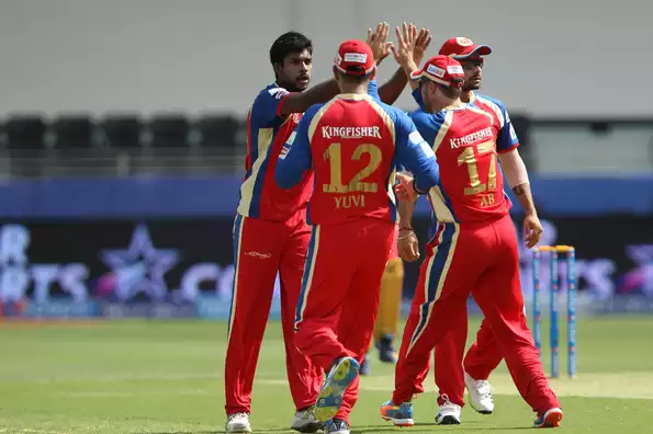 Varun Aaron, along with his teammates, celebrates the wicket of Aditya Tare.