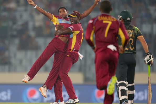 Krishmar Santokie is congratulated by Darren Sammy after dismissing Ahmed Shehzad