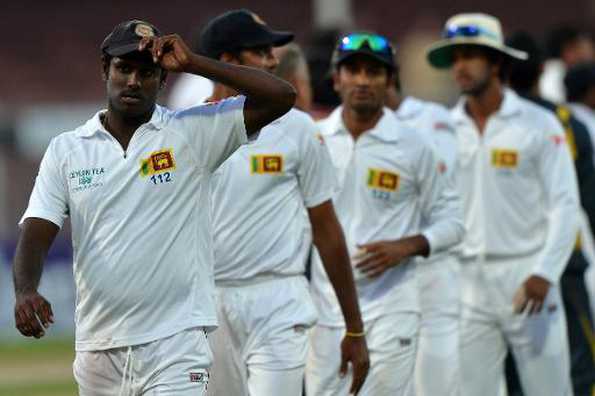 Sri Lanka's cricket team captain Angelo Mathews leaves the field with his teammates after losing to Pakistan in the final day of their third and final cricket Test match in the Gulf emirate of Shrajah on January 20, 2014