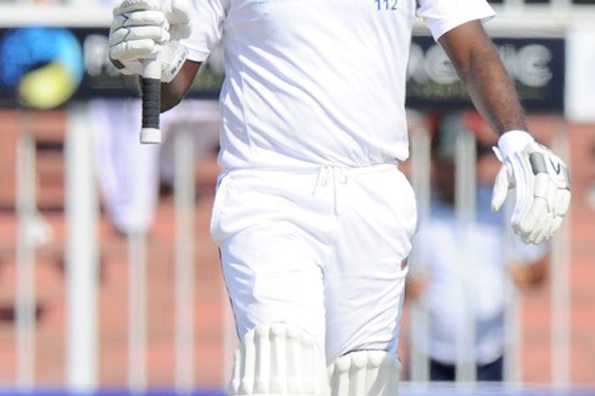 Angelo Mathews raises his bat in celebration after scoring a half-century.