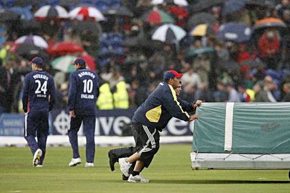 England's Kevin Pietersen (L) and Steve Harmison (2nd L) walk off as the groundstaff put the covers on the wicket due to a further rain delay during the fifth Natwest one day International between England and South Africa at The Swalec Stadium in Cardiff, Wales. England claimed the one-day series 4-0 after only three overs were possible due to heavy rain.