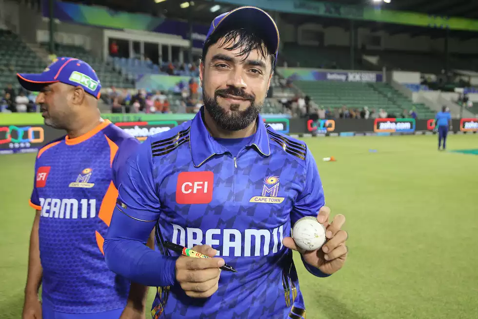 Rashid Khan signs the match ball after the game